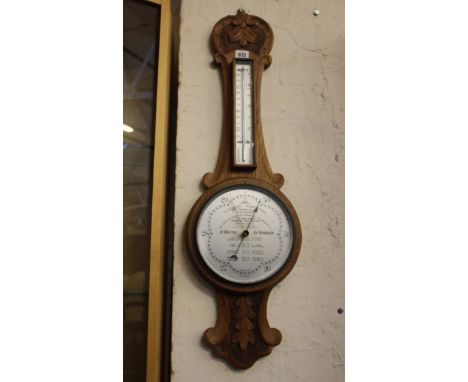 A Wilsn forecast barometer within a carved oak case, presented to B A Voisey 84cm high  
