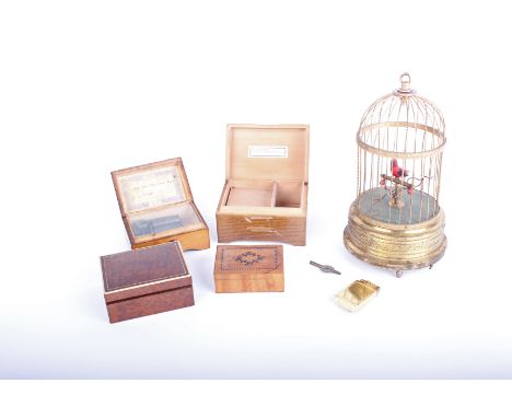 Musical boxes: a bird automation with single bird in a gilt metal cage, mechanism not operational but intact, two small Swiss