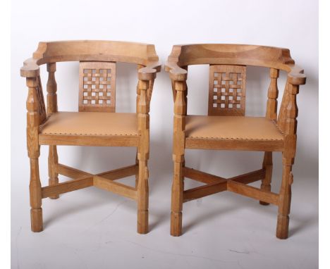 A pair of 'Mouseman' Kilburn yoke back armchairs with carved lattice panel backs and leather seats, Robert Thompson's Craftsm