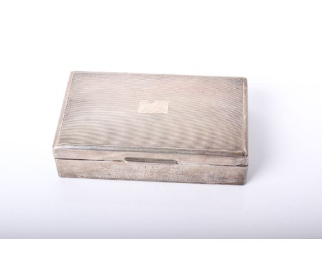 A silver rectangular cigarette box with an engine turned cover and plain sides engraved with a presentation inscription, Lond