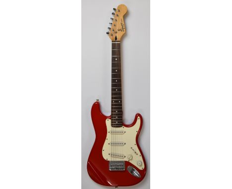 Squire Mini Stratocaster &frac34; size electric guitar by Fender, with 20 frets and red finish, serial no. 040557791, made in