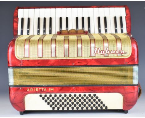 Hohner Arietta IM 36 key piano accordion in red and gold, with leather strap and hard carry case.