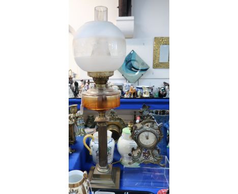 A French champleve enamel mantle clock and a brass and glass oil lamp Condition Report: the oil lamp reservoir is cracked. 