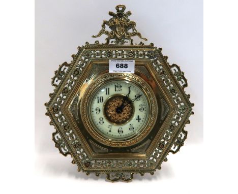 A hexagonal brass strut clock with mask finial, the white enamel dial ring with Arabic numerals, incised BH monogram to the b
