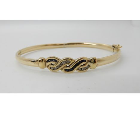 A 9ct gold sapphire and clear gem set bangle, weight 8.7gms Condition Report: Available upon request