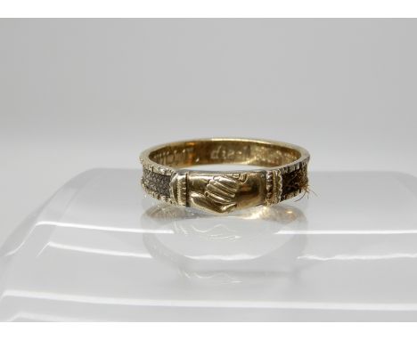 A yellow metal hair panel mourning ring with clasped hands detail inscribed 1862, size N1/2, weight 1.6gms Condition Report: 