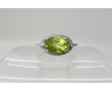 A 14k white gold peridot and diamond ring, size N, weight 3gms Condition Report: Light general wear, a few very tiny flea bit