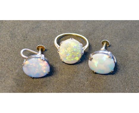 An 18 Carat Gold Opal Set Dress Ring, the oval opal claw set, together with a pair of silver opal set ear clips 