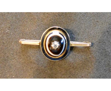 A 9 Carat Gold Mourning Brooch set with a central diamond within cats eye and with an enamel border, locket verso, 5 grammes 