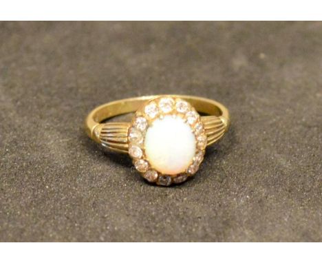 A Gold Opal and Diamond Cluster Ring set with a central oval cabochon opal surrounded by diamonds within a pierced setting, 3