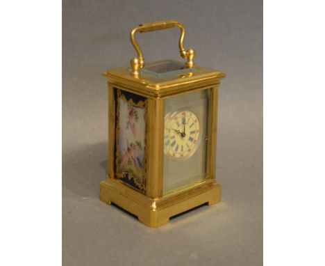 A Miniature Brass Cased Carriage Clock the silvered dial with roman numerals and with painted porcelain side panels and lever