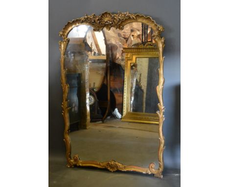 A French Gilded Wall Mirror, with scallop carved cresting and shaped frame 125cm high by 85cm wide 