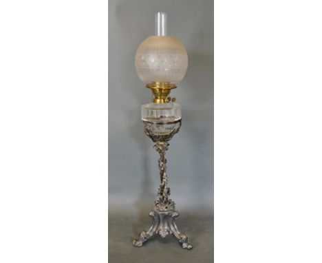 A Late 19th/Early 20th Century Silver Plated Oil Lamp, the column with grape vine and raised upon scroll feet with glass shad