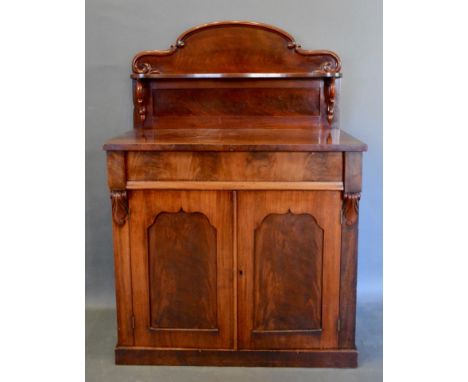 A 19th Century Mahogany Chiffonier, the shaped shelf back above a concealed frieze drawer and two shaped panel doors, raised 