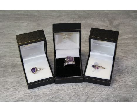 Three silver gem set rings comprising amethyst and white stone ring, the large square mixed cut amethyst measuring 10mm x 10m