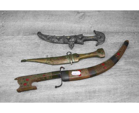 Three Middle Eastern daggers with scabbards to include two tourist examples and a 19th century example with white metal scabb