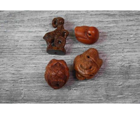 Four miniature wood netsuke figures to include an owl, money giat, bird and another 