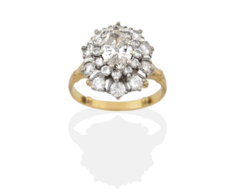 A Diamond Cluster Ring, an oval cut diamond within a border of round brilliant cut diamonds and an outer border of larger rou