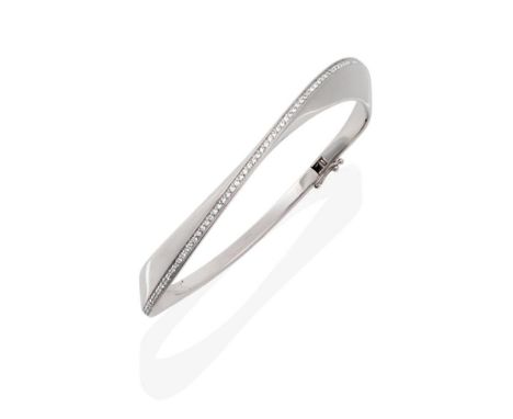 An 18 Carat White Gold Diamond Set Bangle, in a twisting form, with a line of round brilliant cut diamonds along the central 