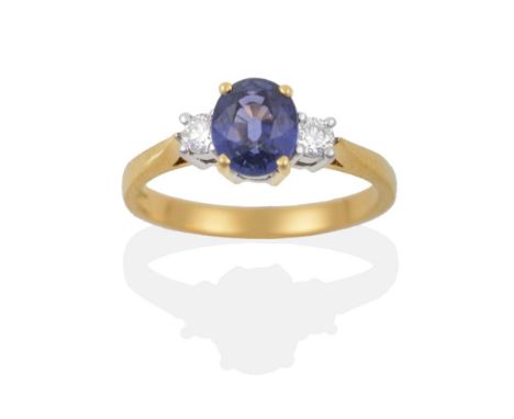 An 18 Carat Gold Sapphire and Diamond Three Stone Ring, the oval cut sapphire sits between two round brilliant cut diamonds, 