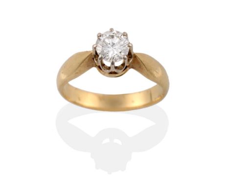 A Diamond Solitaire Ring, the round brilliant cut diamond in a white claw setting, to a yellow tapered shoulder plain polishe