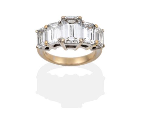 A Diamond Five Stone Ring, set with graduated emerald cut diamonds in white claw settings, on a tapered shoulder plain polish