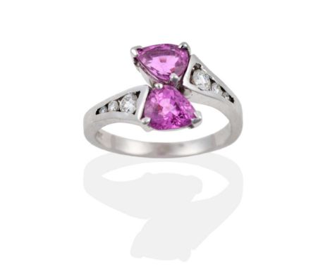 An 18 Carat White Gold Pink Sapphire and Diamond Crossover Ring, two pear cut sapphires create the terminals, each shoulder c