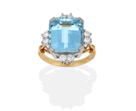 An 18 Carat Gold Aquamarine and Diamond Ring, the emerald-cut aquamarine in white corner claws, with a pair of round brillian