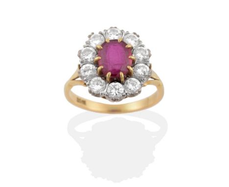 A Ruby and Diamond Cluster Ring, an oval cut ruby in yellow claw settings, within a border of round brilliant cut diamonds in