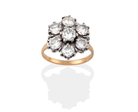 An 18 Carat Gold Diamond Cluster Ring, seven round brilliant cut diamonds in white claw settings, to a yellow tapered shoulde