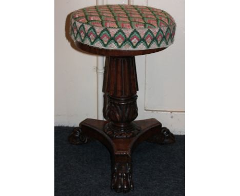 A Regency rosewood piano stool with adjustable seat on column and flat tripod with paw feet