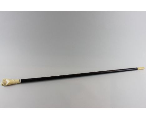 An ivory and hardwood walking stick, the handle carved as a hand clasping a ball, 87cm long