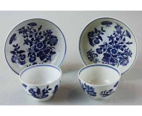 A pair of 18th century Worcester porcelain tea bowls and saucers, hand painted in blue with flowers and butterflies (crescent