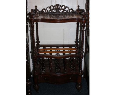 A Victorian figured walnut Canterbury whatnot with serpentine front and open shelf above music racks and drawer at base, on s