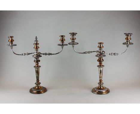 A pair of 19th century Sheffield plated three-light candelabra with scroll shaped branches and tapered turned columns on circ