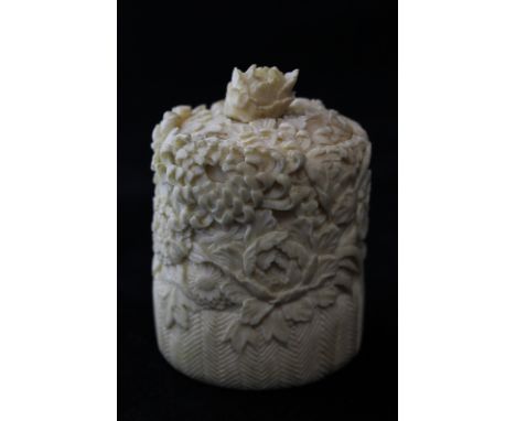 A 19th century oriental (probably Chinese) ivory tusk box intricately carved with flowers, the loose lid top with flower fini