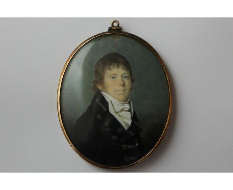 A 19th century oval miniature half portrait of a young man in black coat and lace trimmed shirt, with hair inset and opaque e