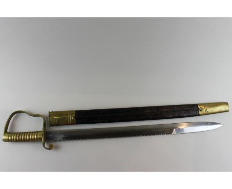 A brass grip and guard short sword with serrated saw edge blade in scabbard, 72cm long