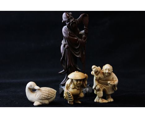 Two small carved ivory netsuke, man with monkey and man with a fan, and another of a duck (all signed) and another carved woo