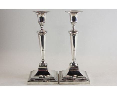 A pair of silver candlesticks, maker Thomas Bradbury and Sons Ltd Sheffield 1925, with tapered turned columns on sloping squa