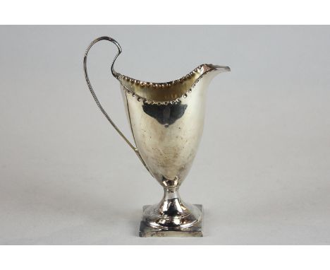 A George III helmet shaped silver cream jug, London 1784, with pinched rim, on stemmed square base, 2.5oz