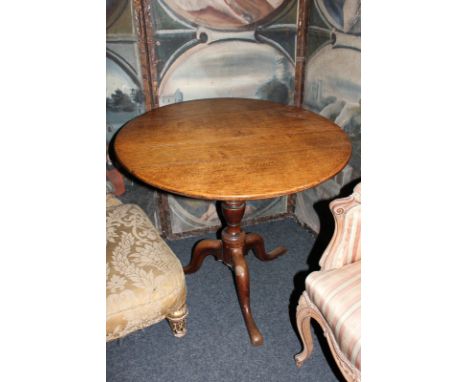 A George III oak tea table with circular tilting top on turned column and tripod base, 78cm