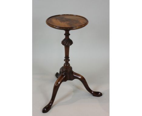 A George III mahogany low candle stand with circular top on turned column and tripod base, 25cm diameter