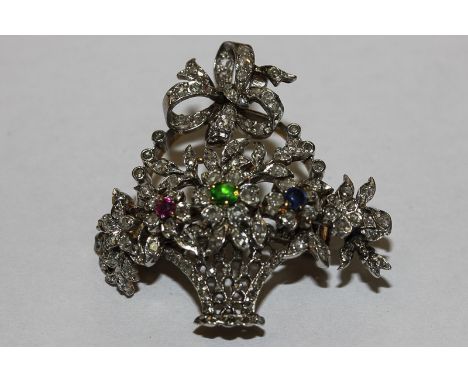 A diamond, ruby and sapphire brooch in the form of a basket of flowers, set throughout with rose cut diamonds and coloured st