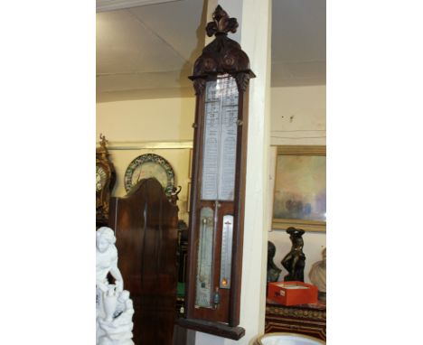 A 19th century Admiral Fitzroy's barometer in oak case with carved crest and scale 27 to 31 inches, with marker and pointer a