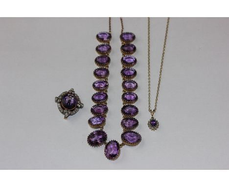 An amethyst and diamond brooch/pendant oval cut within a border of graduated bead set old cut diamonds, a smaller pendant and