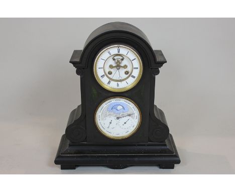 A Victorian black slate mantel clock and calendar the circular dial with visible escapement and dial below, with date, day an