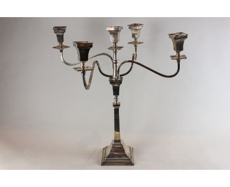 A silver candelabra, Birmingham 1961, with four scroll shaped branches and centre light, all with square sconces on single ca