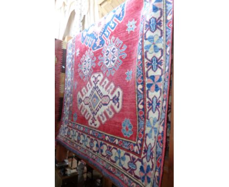 Large handmade Caucasian style rug on red ground 2.3m x 1.4m