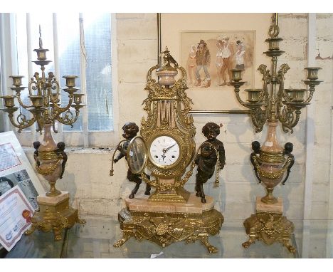 Continental ormolu, bronze and marble clock garniture set by Imperial, the clock being flanked by bronze putti and the candle